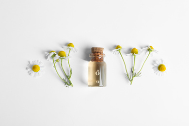 Photo of Flat lay composition with chamomile essential oil on white background