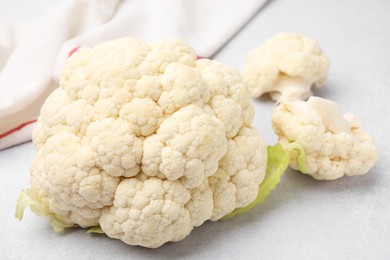 Cut fresh raw cauliflower on light grey table, closeup
