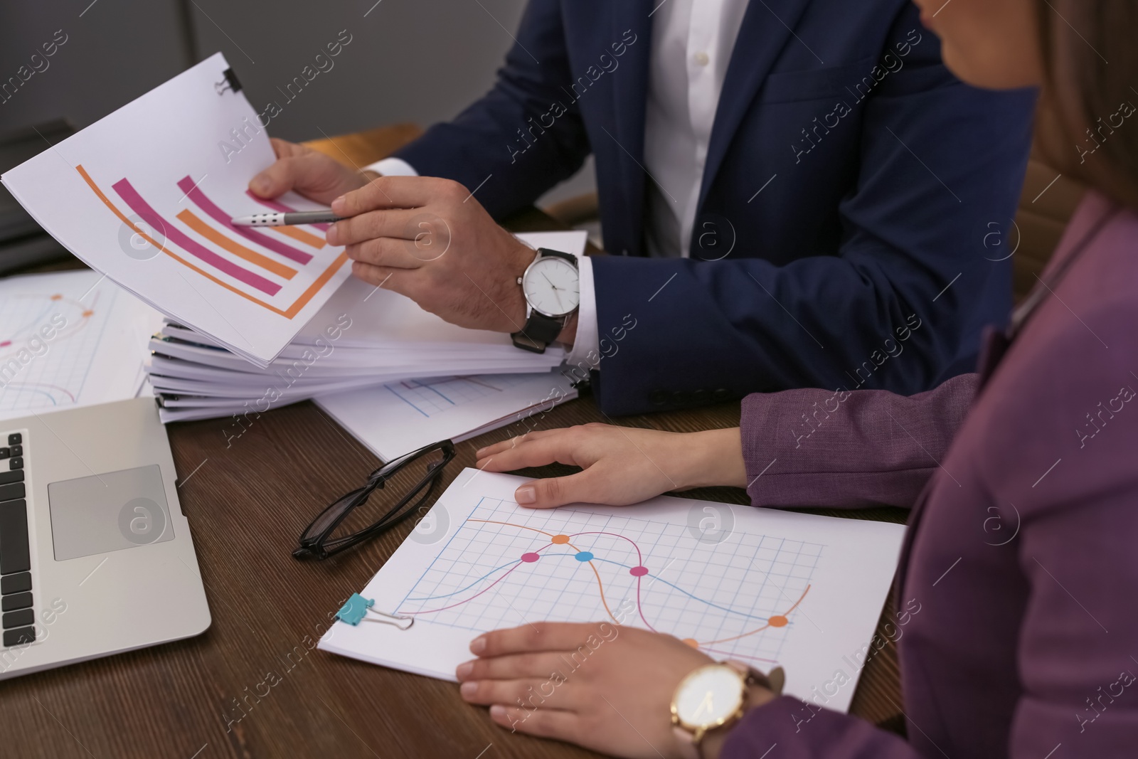 Photo of Businessman and assistant working with documents at table, closeup