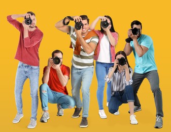 Image of Group of professional photographers with cameras on orange background