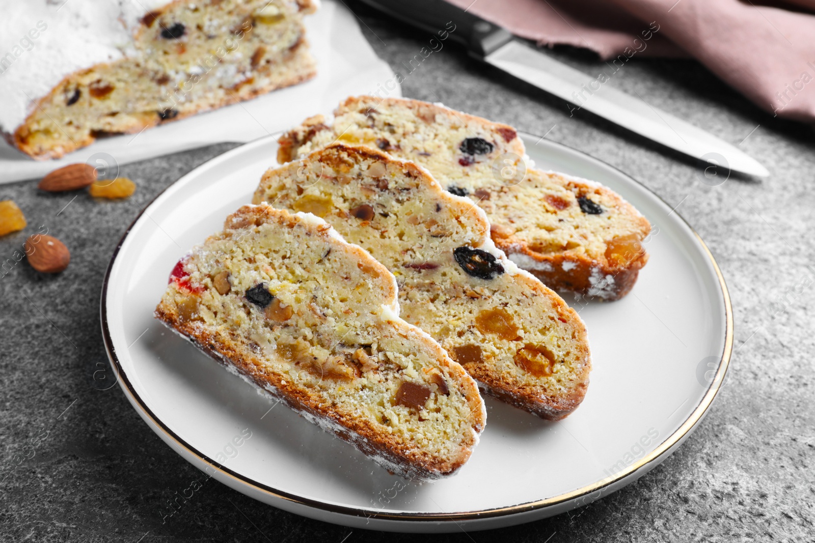 Photo of Traditional Christmas Stollen with icing sugar on grey table