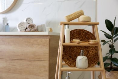 Dispensers and different toiletries on decorative ladder in bathroom. Idea for interior design