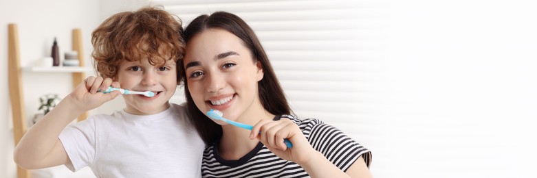 Mother and her son brushing teeth together in bathroom. Banner design with space for text