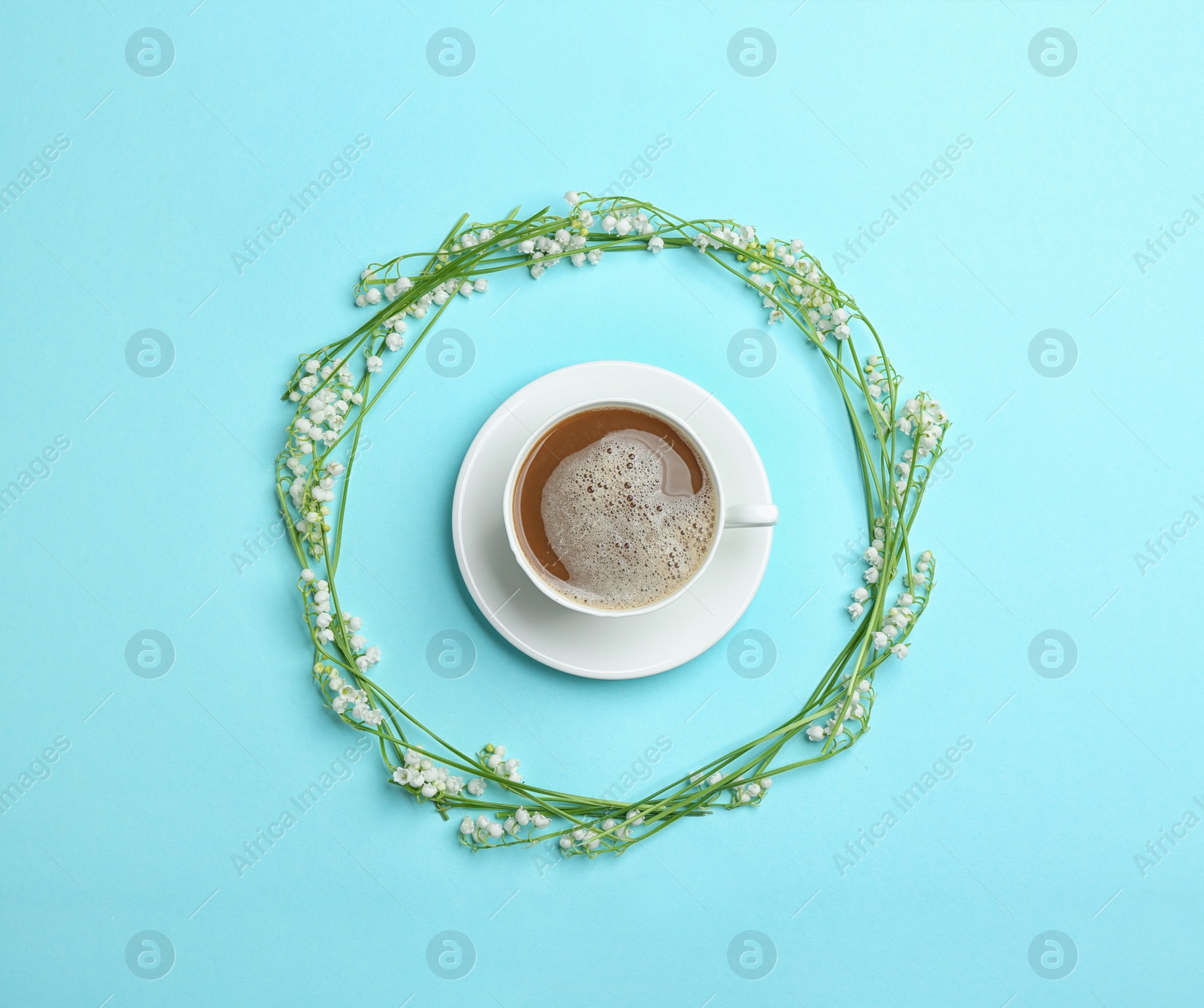 Photo of Frame made with lily of the valley flowers and coffee on color background, flat lay
