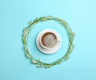 Frame made with lily of the valley flowers and coffee on color background, flat lay