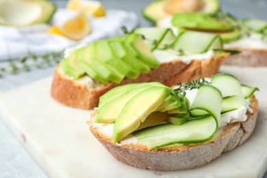 Photo of Tasty sandwiches with avocado and cucumber on table, closeup