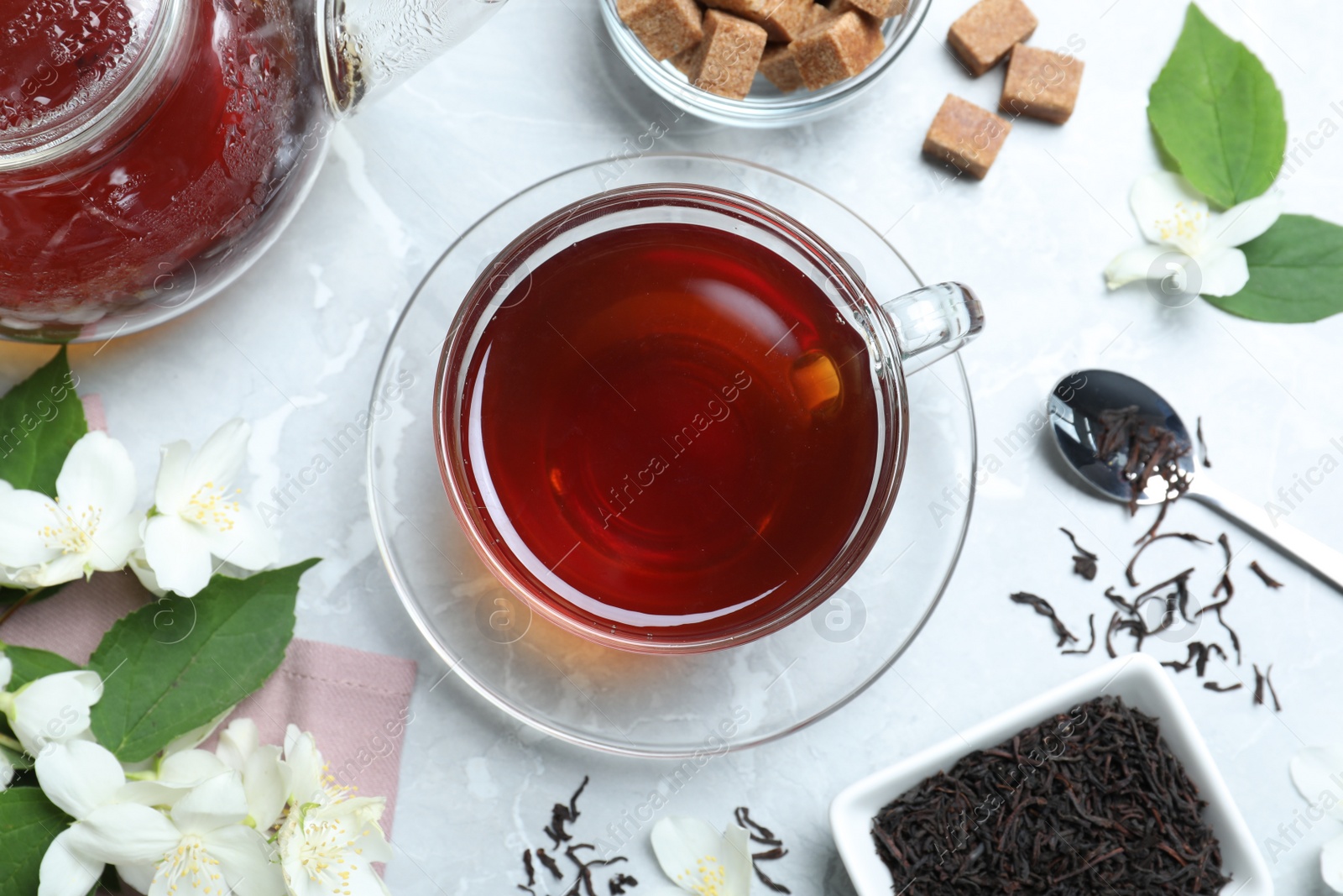 Photo of Flat lay composition with tea and fresh jasmine flowers on light grey marble table