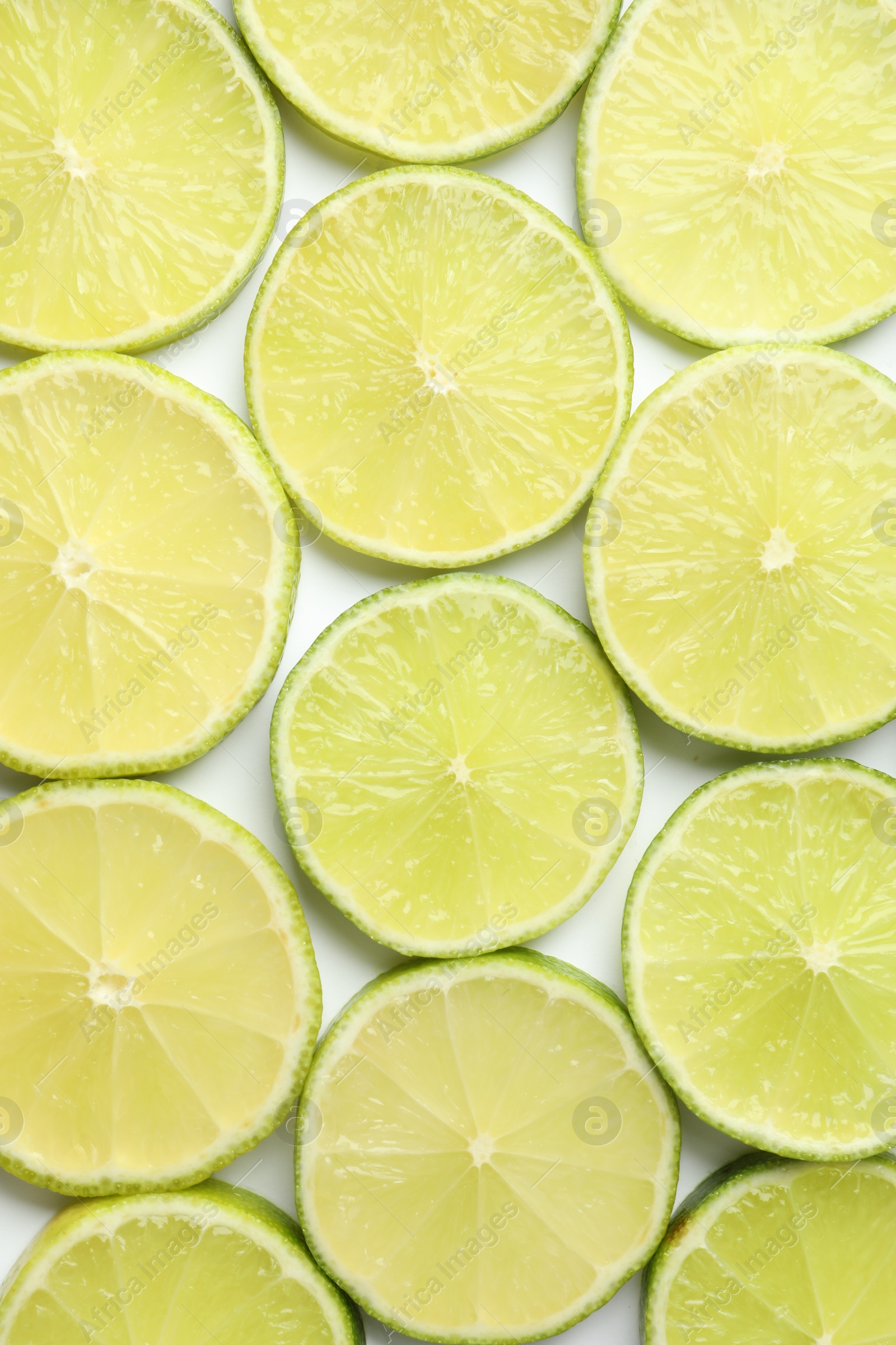 Photo of Fresh juicy lime slices on white background, flat lay