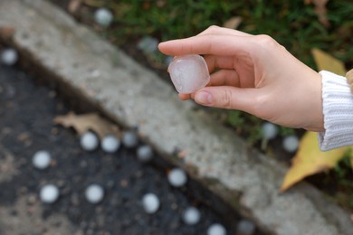 Photo of Woman holding hail grain after thunderstorm outdoors, closeup