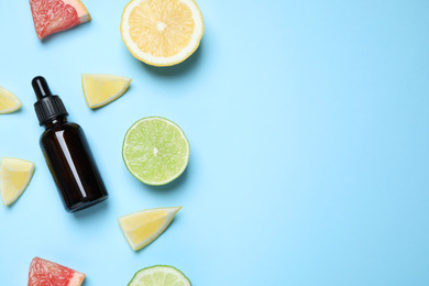 Photo of Flat lay composition with citrus essential oil on light blue background. Space for text