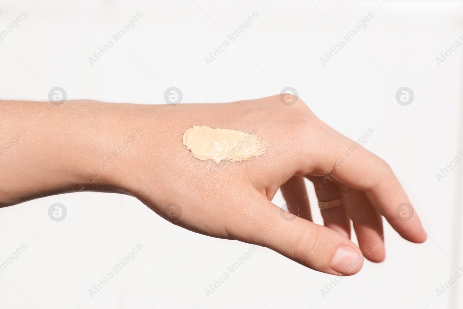 Photo of Woman testing foundation tone on hand, closeup