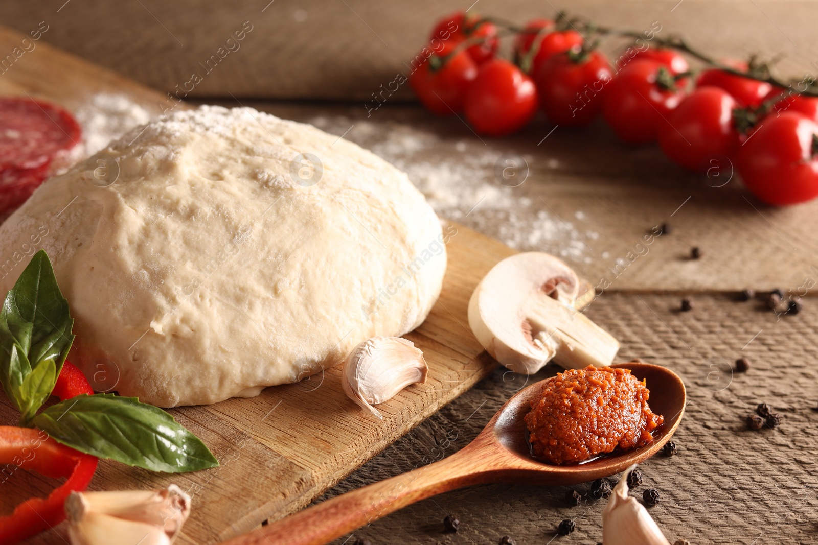 Photo of Pizza dough and products on wooden table, closeup