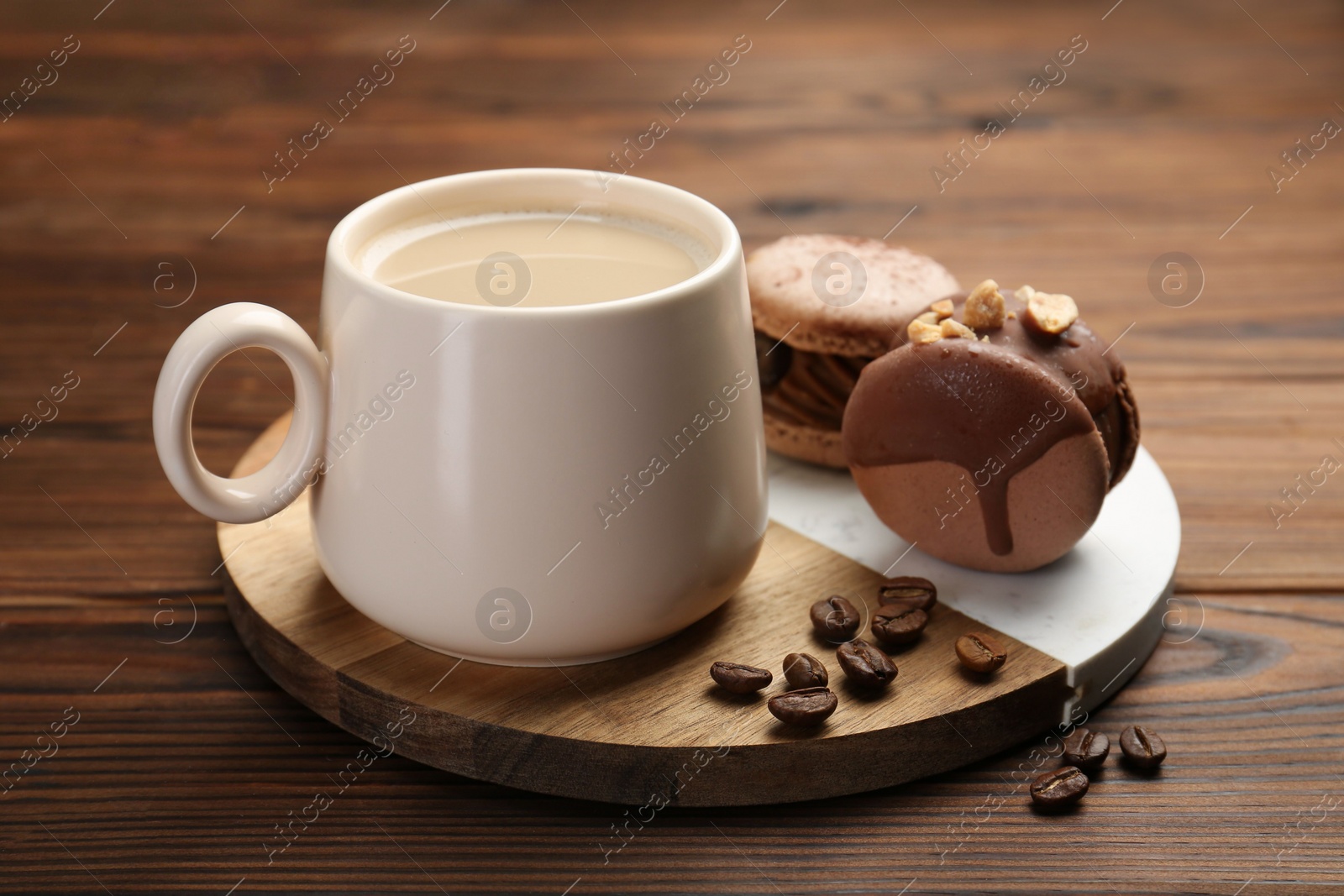 Photo of Cup of coffee and delicious macarons on wooden table