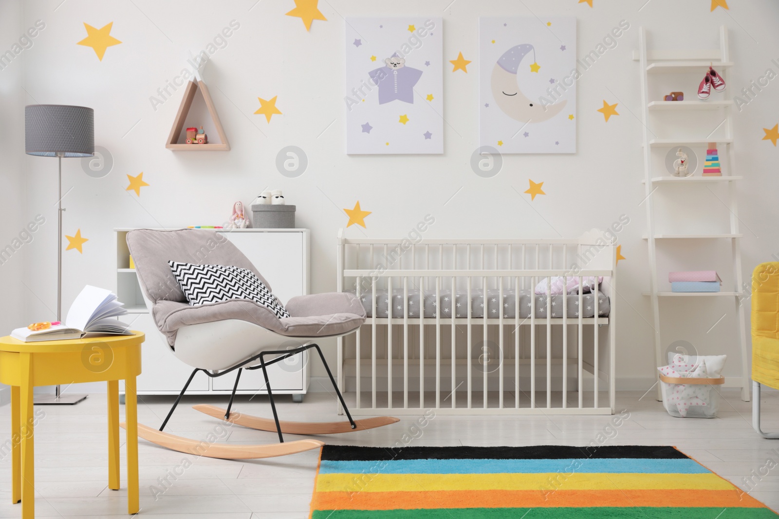 Photo of Stylish baby room interior with crib and rocking chair