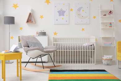 Photo of Stylish baby room interior with crib and rocking chair