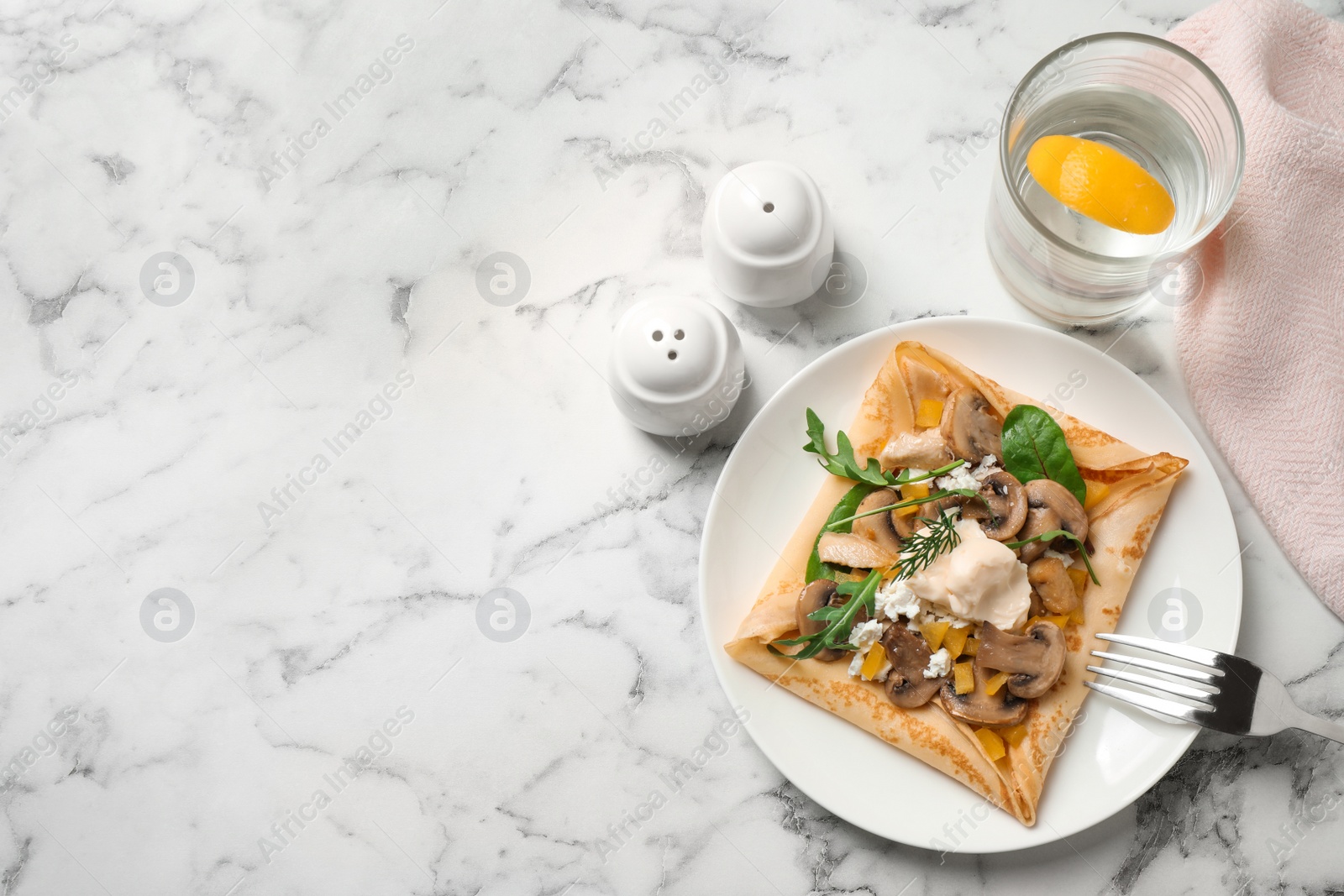 Photo of Delicious breakfast with thin pancakes on marble table, flat lay. Space for text