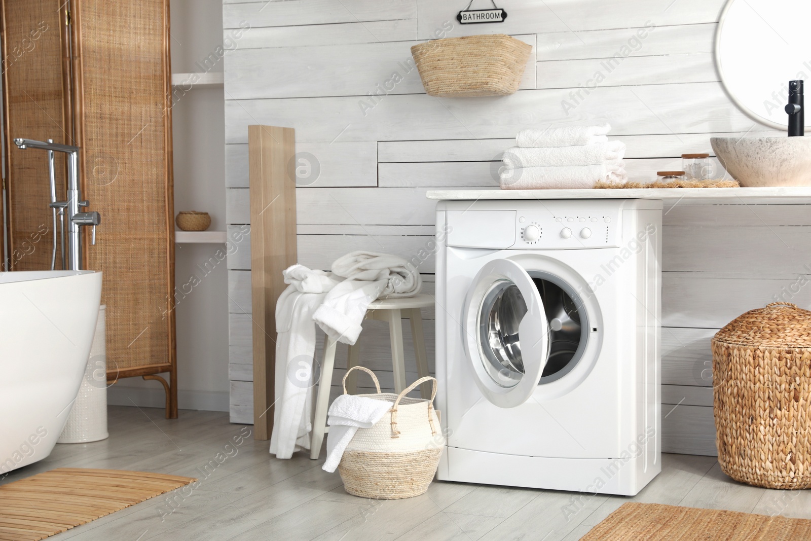 Photo of Stylish bathroom interior with modern washing machine