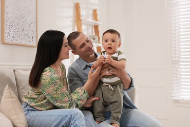 Portrait of happy family with little child at home