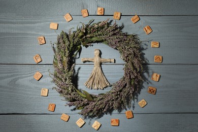 Photo of Female voodoo doll, wreath and runes on grey wooden background, flat lay