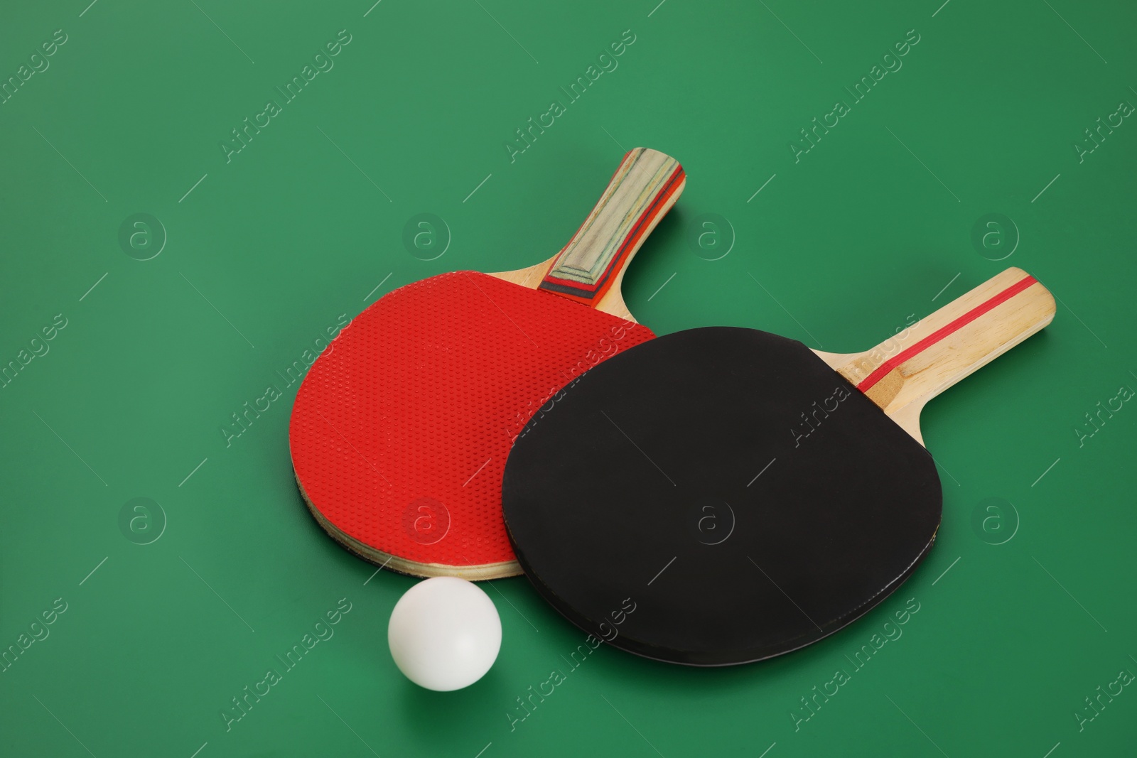 Photo of Rackets and ball on green background. Ping pong