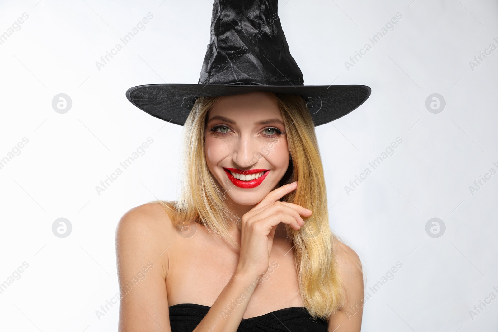 Photo of Beautiful woman in witch costume on white background. Halloween party