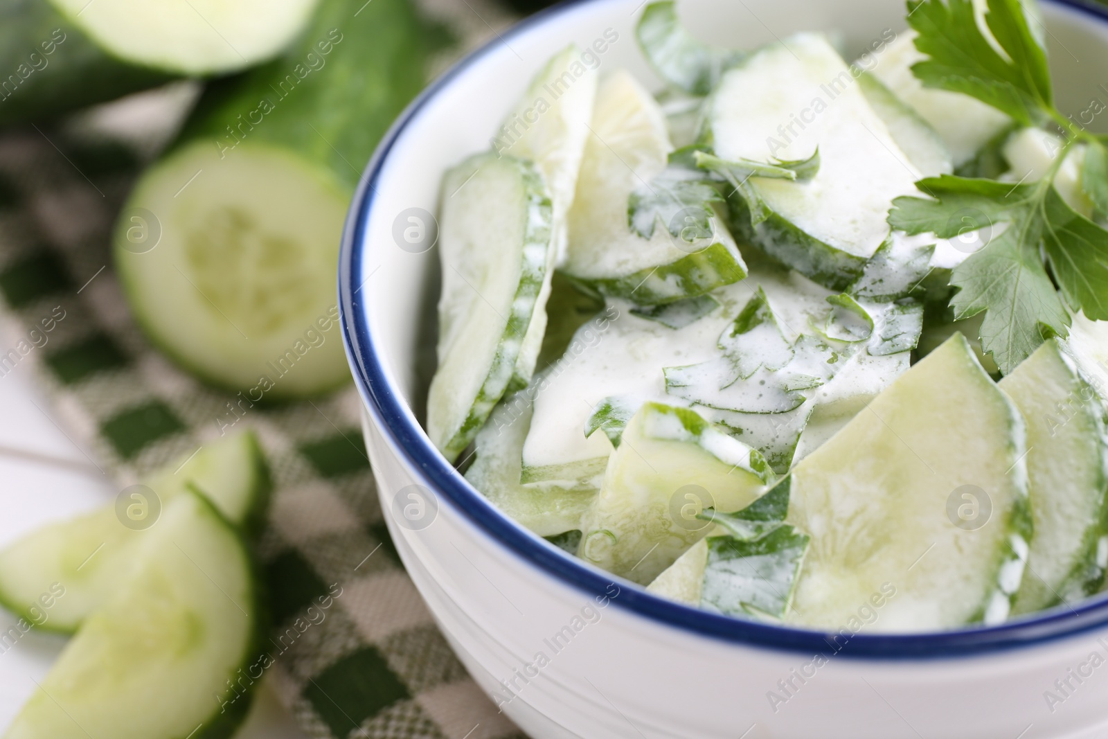 Photo of Delicious cucumber salad in bowl on table, closeup. Space for text