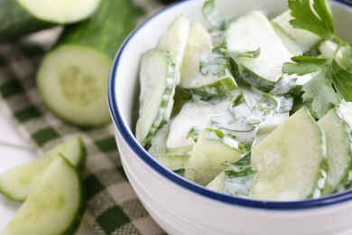 Photo of Delicious cucumber salad in bowl on table, closeup. Space for text