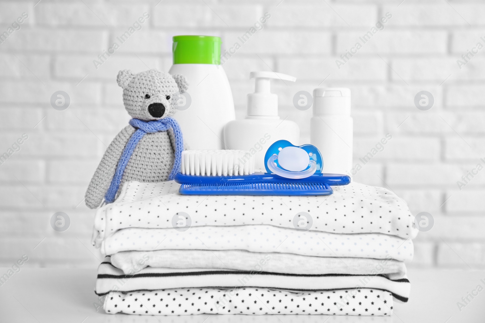 Photo of Baby accessories on table near white brick wall