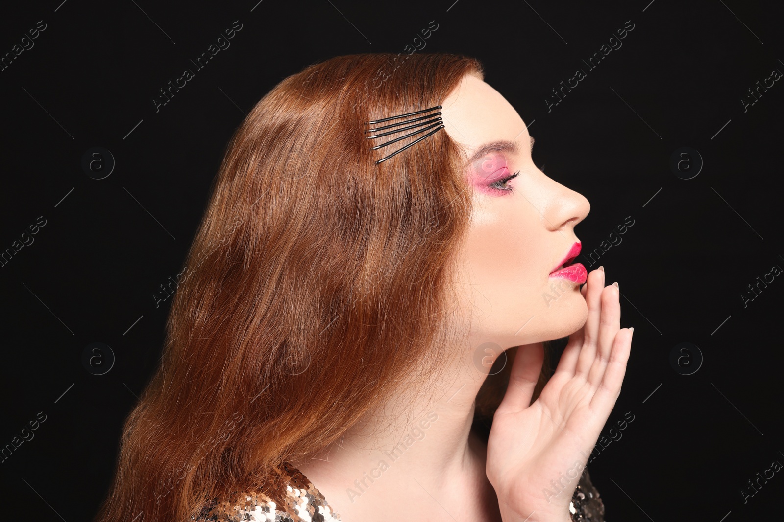 Photo of Portrait of beautiful young woman with makeup posing on black background