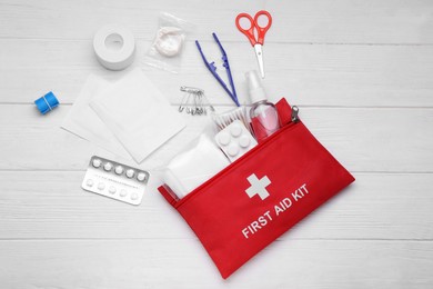 Photo of Flat lay composition with first aid kit on white wooden table