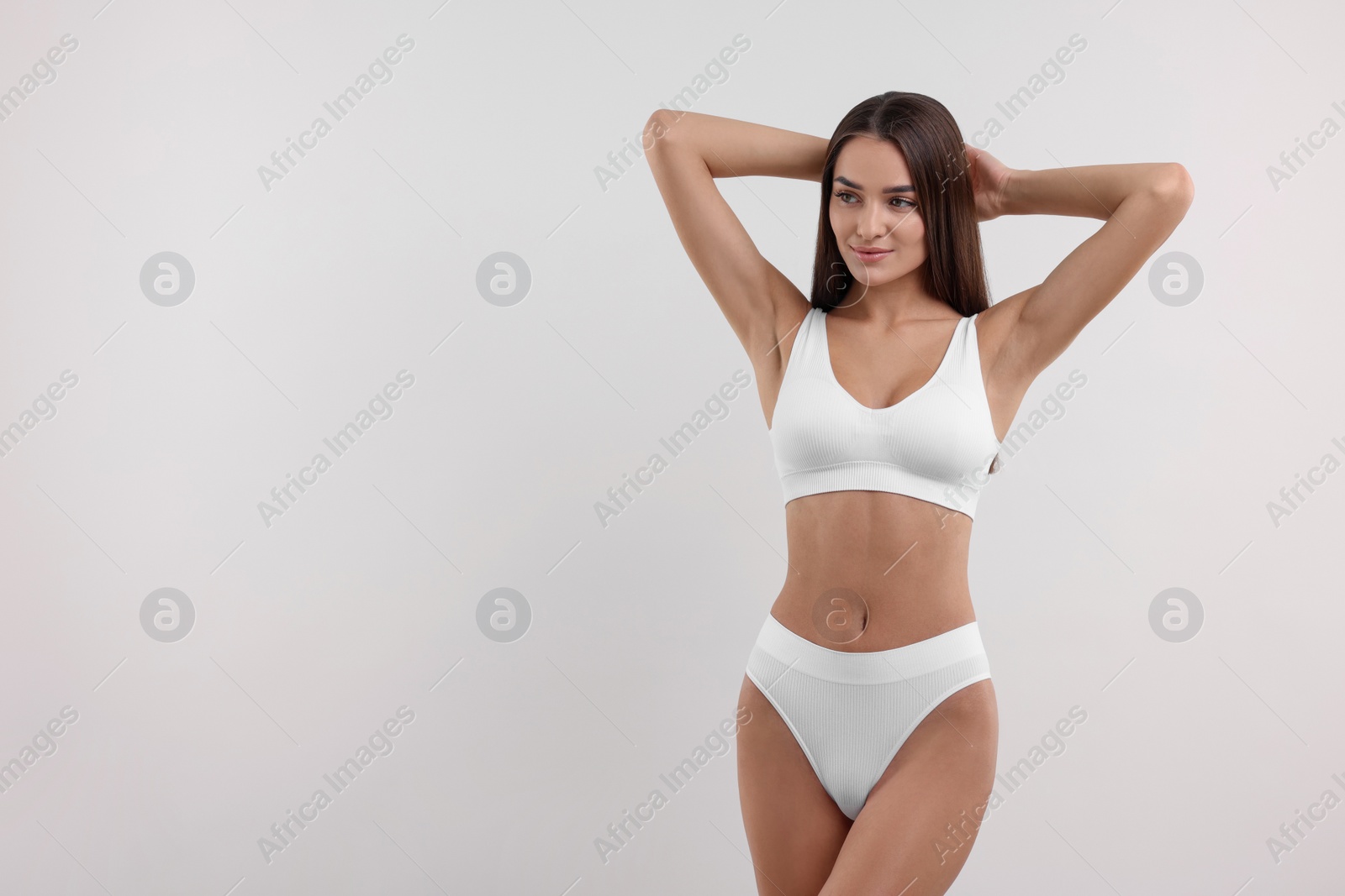 Photo of Young woman in stylish bikini on white background