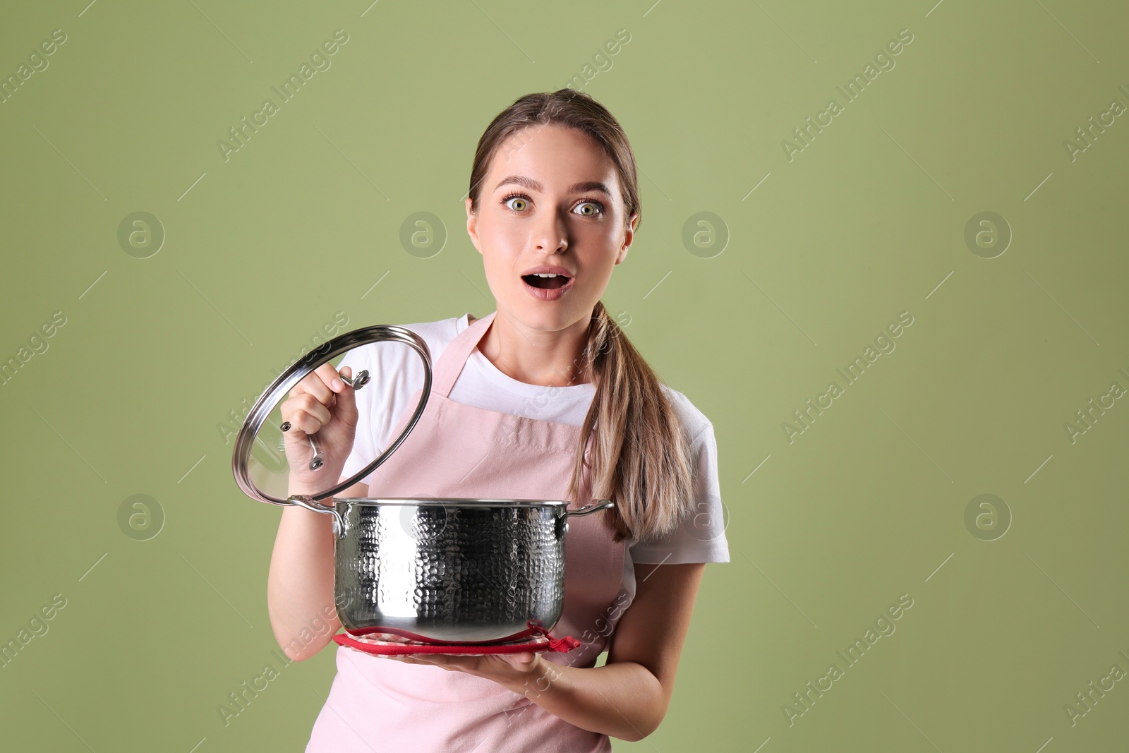 Photo of Surprised woman with pot on olive background
