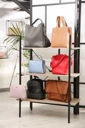 Photo of Collection of stylish woman's bags on rack in store
