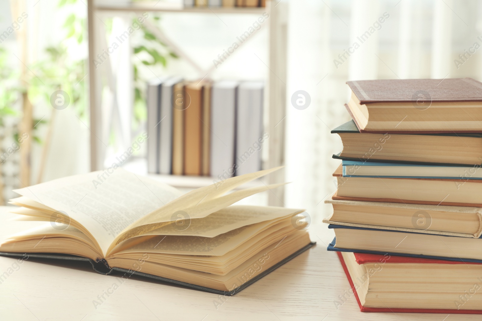 Photo of Open hardcover book on white wooden table indoors