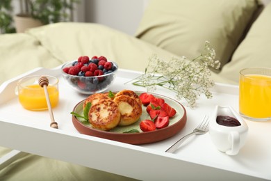 Tasty breakfast served in bedroom. Cottage cheese pancakes with fresh berries and mint on white tray