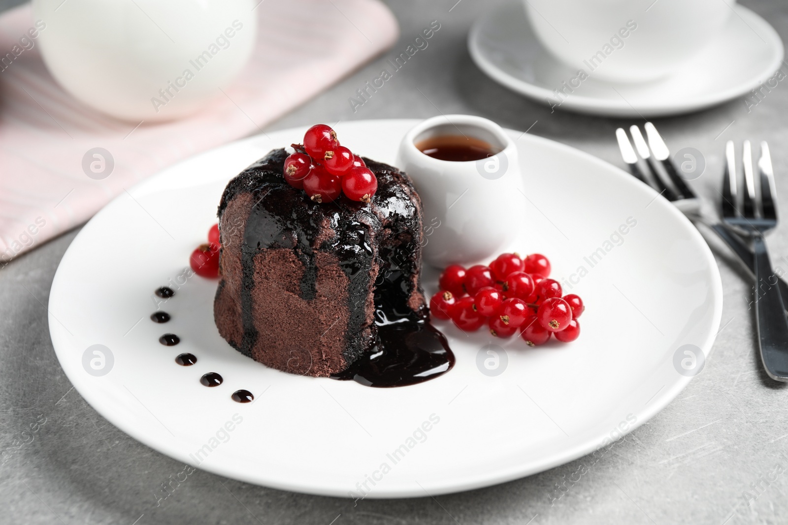 Photo of Delicious warm chocolate lava cake with berries on grey table