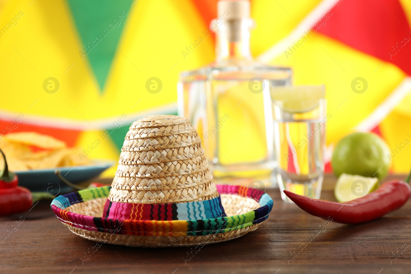 Photo of Mexican sombrero hat and chili pepper on wooden table