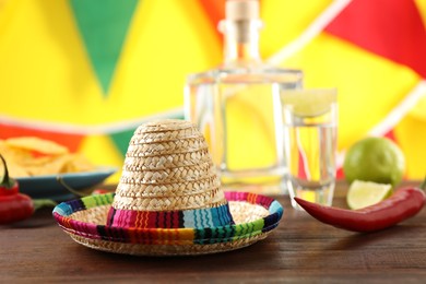 Mexican sombrero hat and chili pepper on wooden table