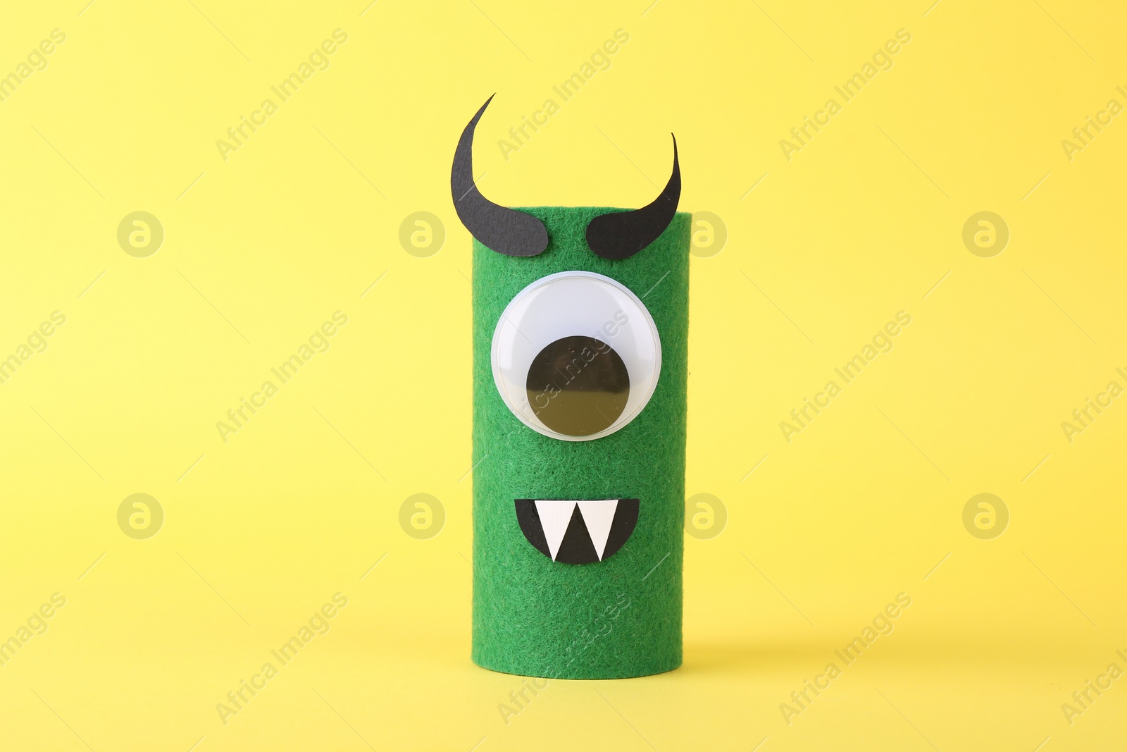 Photo of Spooky monster on yellow background. Handmade Halloween decoration