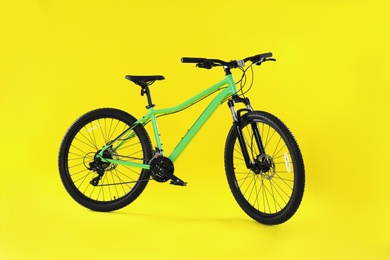 Photo of Modern bicycle on yellow background. Healthy lifestyle