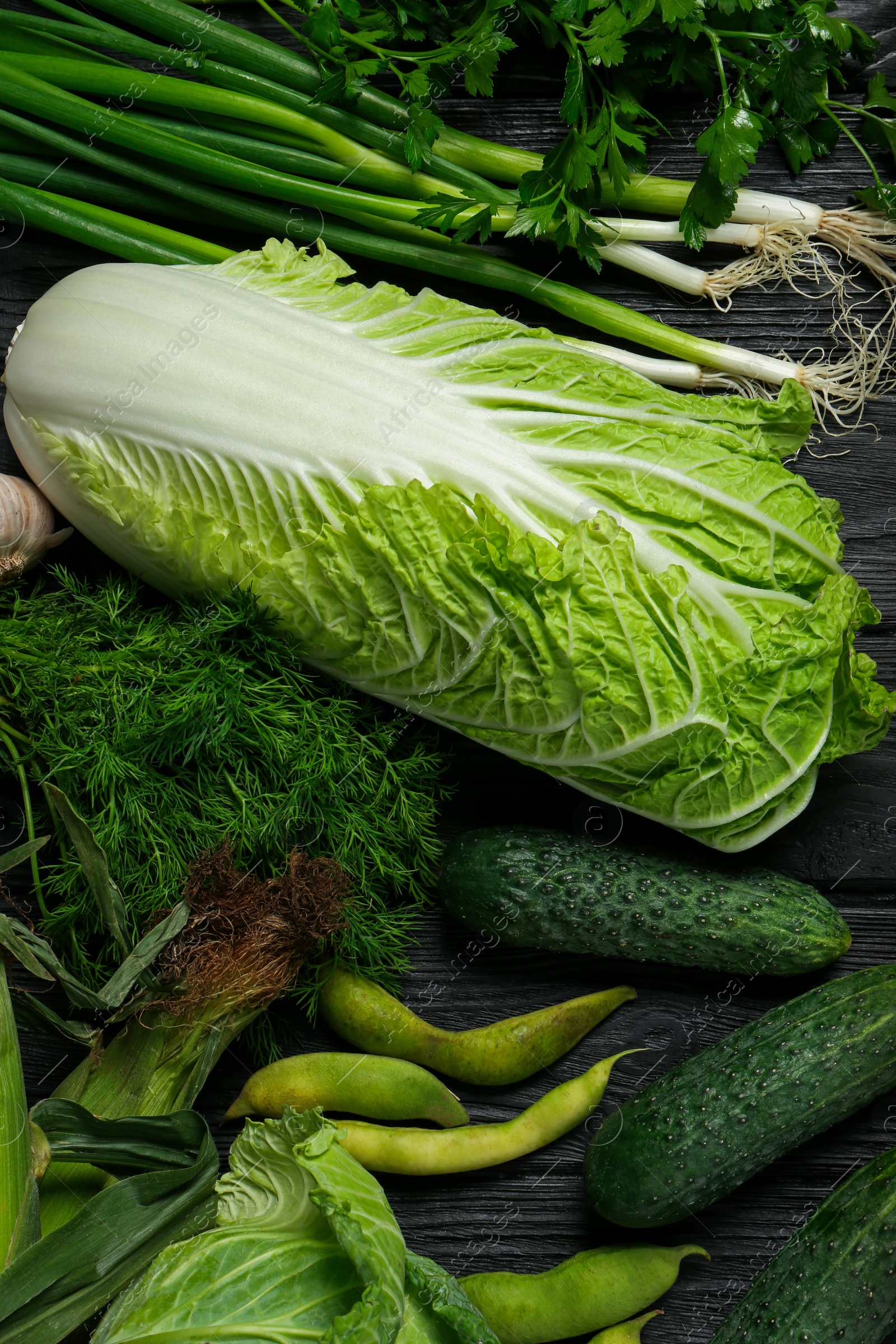 Photo of Different fresh ripe vegetables on black wooden table, flat lay. Farmer produce