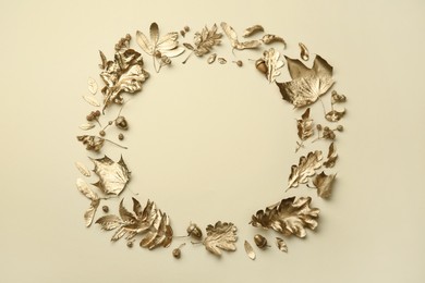 Frame made of different golden leaves on beige background, flat lay with space for text. Autumn decor