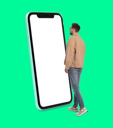 Image of Man walking towards big smartphone on green background