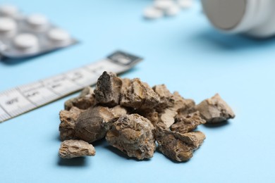 Photo of Pile of kidney stones on light blue background, closeup