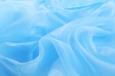 Photo of Beautiful light blue tulle fabric as background, closeup