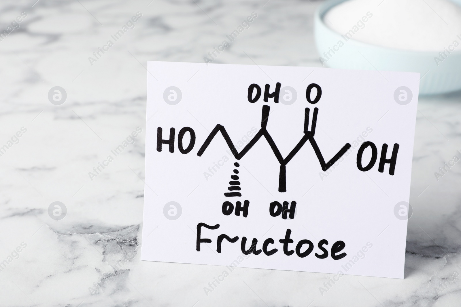 Photo of Paper with word Fructose and drawn scheme on white marble table