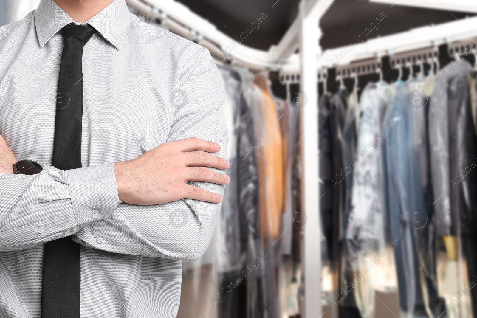 Image of Businessman and garment conveyor at dry-cleaner's, closeup. Space for text 