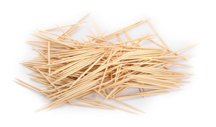 Photo of Heap of wooden toothpicks on white background