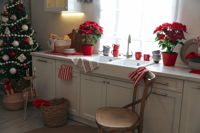 Photo of Beautiful kitchen interior with Christmas tree and festive decor