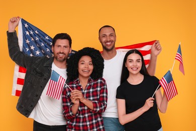 Photo of 4th of July - Independence Day of USA. Happy friends with American flags on yellow background